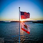 American and Californian Flags Backlit at Sunset