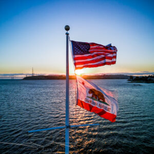 American and Californian Flags Backlit at Sunset