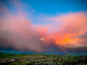 Cotton Candy Pink Clouds Illuminated Above Green Hills