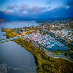 The morning sun illuminates the boat docks at Benicia Harbor. The city of Benicia stretches out in the background, gradually awakening with the dawn.