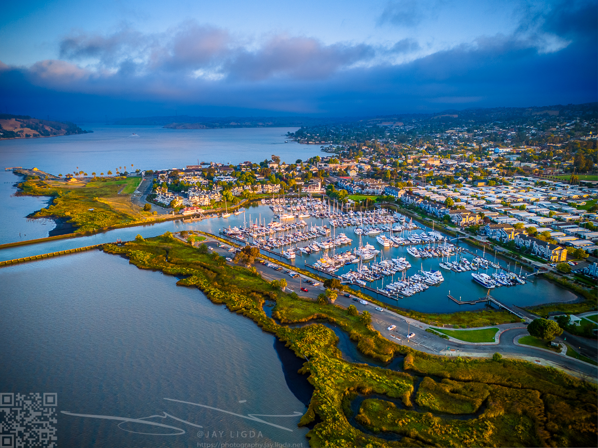 The morning sun illuminates the boat docks at Benicia Harbor. The city of Benicia stretches out in the background, gradually awakening with the dawn.